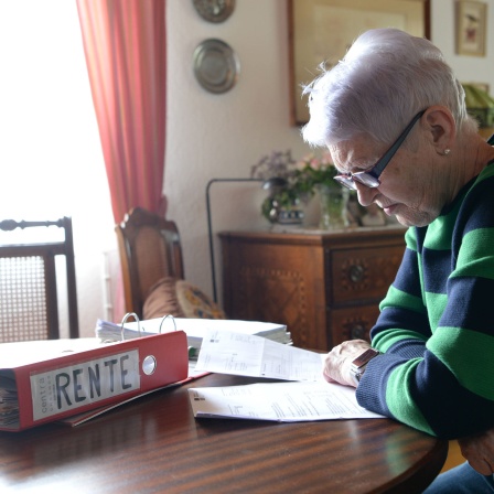 Seniorin schaut ihre Rentenunterlagen durch