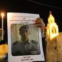 Ein Palästinenser hält am 05.02.2015 in Bethlehem eine Kerze und ein Portrait von dem vom IS ermordeten jordanischen Piloten Muath al-Kasasbeh in den Händen.