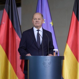 Olaf Scholz vor der Fahne der Europäischen Union