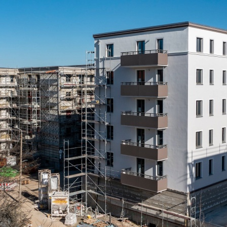Neue Wohnanlagen des Sozialen Wohnungsbaus sind zu sehen - teils gerade fertiggestellt, teils noch als Rohbau.
