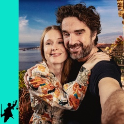 Die Schauspielerin Odine Johne und der Schauspieler Oliver Wnuk mit einem Selfie vor dem Panorama der Bucht von Taormina