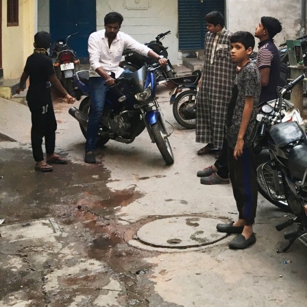 Indische Männer stehen in einem Hinterhof