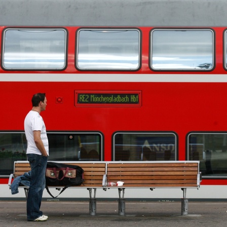 Ein Reisender steht im Hauptbahnhof Essen vor einem Regionalzug