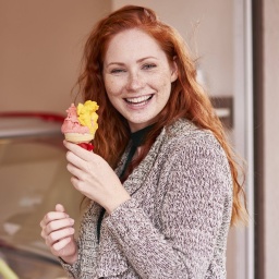 Eine rothaarige Frau isst Eis.