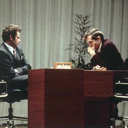 Boris Spasski und Bobby Fischer beugen sich über ein Schachbrett bei der Schach-WM 1972