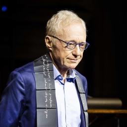 David Grossman steht bei der Verleihung des Erasmus-Preises 2022 in Amsterdam im königlichen Palast vor einem dunklen Hintergrund.