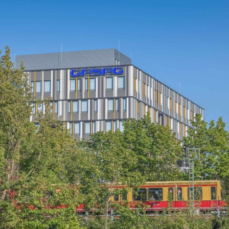 Eine S-Bahn fährt vor der Zentrale der Gasag in Schöneberg.