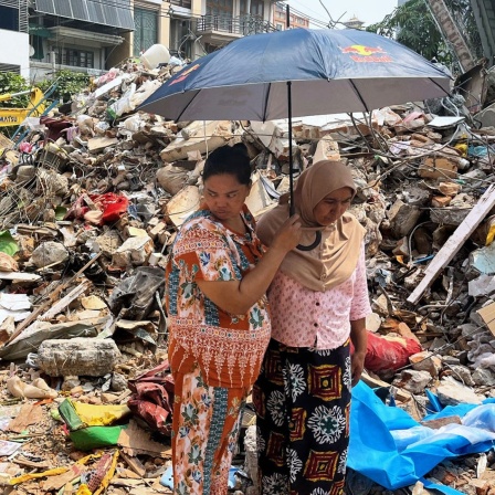 Nach dem schweren Erdbeben in Myanmar halten sich Menschen in der Stadt Mandalay vor ihrem eingestürzten Haus auf. (Foto vom 3.4.2025)