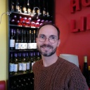 Ein Mann vor einem Weinregal