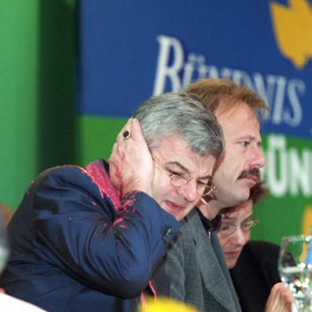 Von einem Farbbeutel getroffen, faßt sich Bundesaußenminister Joschka Fischer am 13.5.1999 auf dem Sonderparteitag der Grünen in Bielefeld erschrocken ans Ohr.