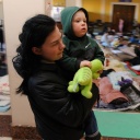 Eine Mutter trägt ihr Kind in einem Raum für Frauen und Kinder, die vor der russischen Invasion im VIP-Raum des Bahnhofs in Lwiw geflohen sind.