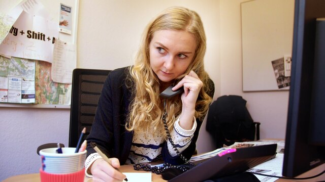 Lokaljournalistin Anna Petersen an ihrem Schreibtisch bei der Telefonrecherche.