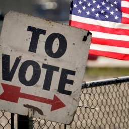 Ein Wahlschild und eine amerikanische Flagge sind vor einem Vorwahlbüro in Dearborn, Michigan zu sehen