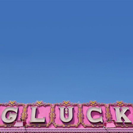Glück – Schriftzug an einer Jahrmarkt-Bude; © dpa/Westend61/Guntmar Fritz
