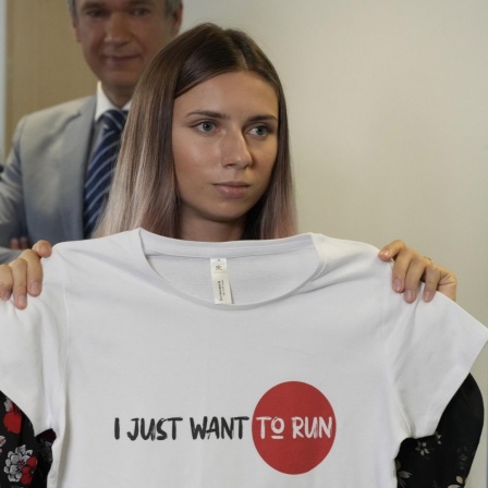 Sprinterin Kristina Timanowskaja in Warschau nimmt an einer Pressekonferenz teil und zeigt ein T-Shirt mit dem Slogan "I Just Want to Run".