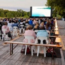 Zuschauer verfolgen beim Festival des deutschen Films auf einer großen LED-Videoleinwand einen Kinofilm.