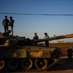 Kinder stehen auf einem Panzer der syrischen Regierungstruppen, der auf einer Straße in der Stadt Marea am Rande der Stadt Aleppo zurückgelassen wurde.