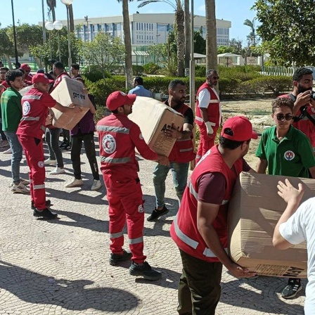 Helfer laden Hilfspakete in Kairo für die Menschen in Gaza auf Laster (Bild: picture alliance / Anadolu | Stringer) 