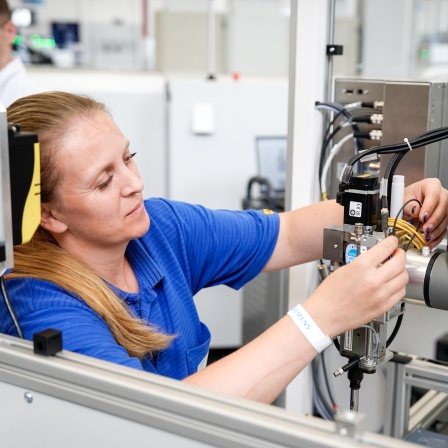 Symbolbild Mitarbeiterin bei der Montage eines Fertigungsroboters fuer die Fertigungsstraße im Gerätewerk der Siemens AG in Erlangen.