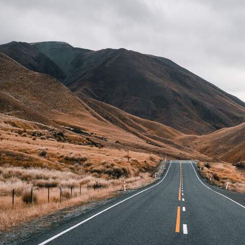 Eine Straße führt durch eine neuseeländische Landschaft (Foto: imago images / Addictive Stock)