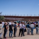 Asylsuchende stehen an der Grenze in Jacumba, Kalifornien, während ihnen Freiwillige Getränke und Snacks reichen.