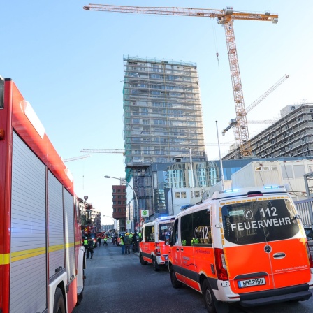 Einsatzfahrzeuge der Feuerwehr stehen in der Nähe einer Baustelle in der Hafencity, auf der es einen tödlichen Unfall gegeben hat.