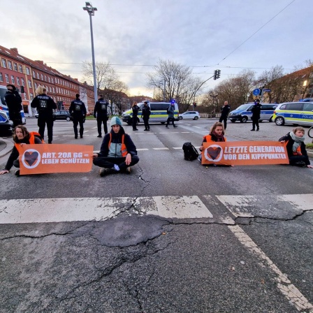 Demonstranten der "Letzten Generation" haben sich in Erfurt auf einer Straße festgeklebt.