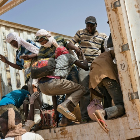 Flüchtlinge in Nordafrika klettern auf die Ladefläche eines Lastwagen.