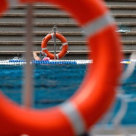 Rettungsringe hängen am Rand eines Schwimmbads.