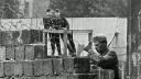 61 Jahre Mauerbau: ostdeutsche Grenzpolizisten beobachten Ausbesserungsarbeiten, 1962; © AP Photo/Peter Hillebrecht