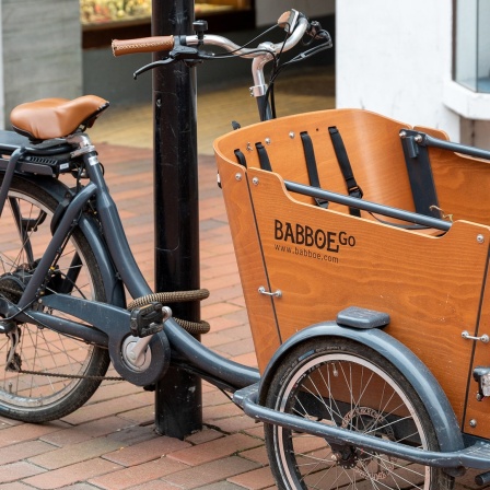 Ein Lastenrad der niederländischen Marke "Babboe" an einen Laternenpfahl geschlossen 