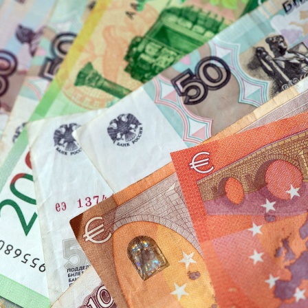 Russische Rubel-Banknoten und Euroscheine liegen auf einem Tisch. 