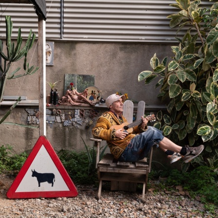 Manu Chao sitzt mit Ukulele schief in einem Stuhl | Bild: Moises Samam Magnum