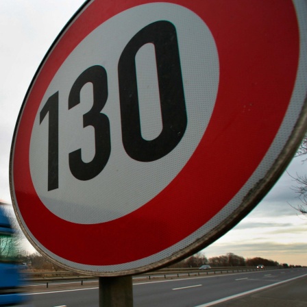 An einer Autobahn steht ein Schild, das die erlaubte Höchstgeschwindigkeit mit 130 km/h anzeigt.