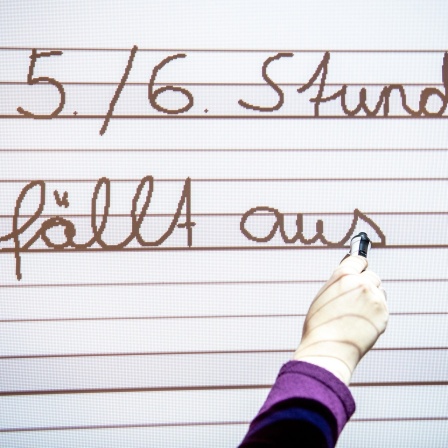 Eine Lehrerin schreibt auf ein Smartboard, auch Whiteboard genannt, in einer Grundschule das die fünfte und sechste Stunde ausfällt. 