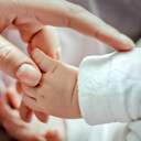 Babyhand in Erwachsenenhand; © imago-images.de/Cavan Images
