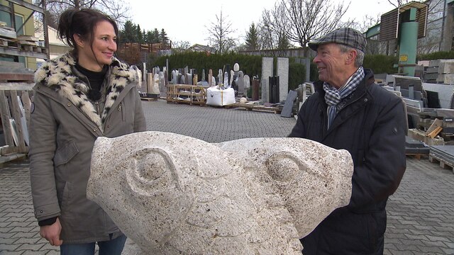 Mobil-Reporterin Petra Thaidigsmann steht mit einem Mann hinter einer Skulptur