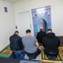 Ein muslimischer Seelsorger betet gemeinsam mit Häftlingen im Gebetsraum in einer Justizvollzugsanstalt.