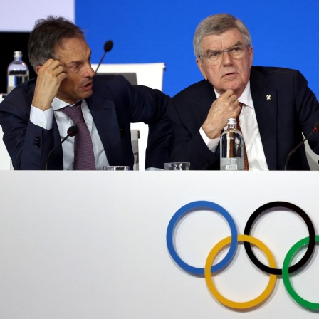 IOC-Präsident Thomas Bach und IOC-Direktor Christophe De Kepper sitzen beim 144. Treffen des IOC in Griechenland