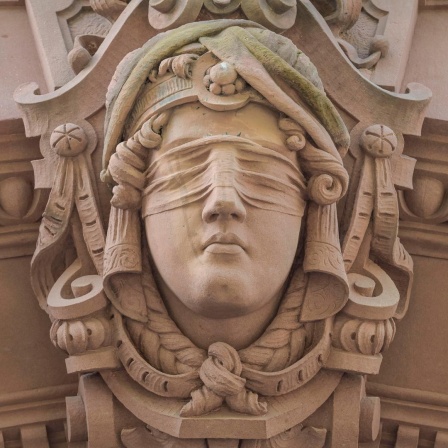 Am Alten Gericht in Wiesbaden hängt eine Sandstein-Skulptur von Justitia, das Abbild einer Frau mit verbundenen Augen