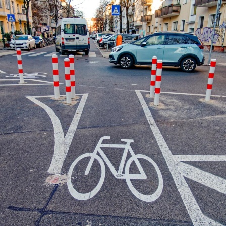 Fahrradstreifen auf der Straße, im Hintergrund Pkw.