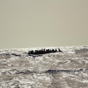 Ein Holzboot mit etwa 30 Menschen versucht bei hohen Wellengang die gefährliche Überfahrt nach Italien. Oft geraten diese labilen und überfüllten Boote in Seenot.