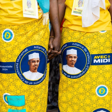 Bei einer Wahlkampfveranstaltung tragen Frauen gelbe Kleider mit dem Konterfei von Mahamat Idriss Déby auf den Röcken.