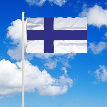 Flagge von Finnland vor blauem Himmel mit weißen Wolken