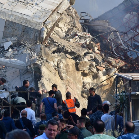 Rettungskräfte arbeiten an einem zerstörten Gebäude, das bei einem Luftangriff getroffen wurde. 