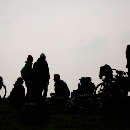 Dunkle Umrisse von Jugendrissen gegen einen grauen tristen Himmel