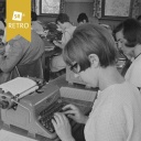 Junge Frauen und Männer tippen auf der Schreibmaschine