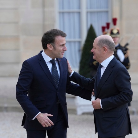 Der französische Präsident Emmanuel Macron,l, begrüßt den deutschen Bundeskanzler Olaf Scholz (SPD) bei seiner Ankunft zu einem informellen Treffen der Staats- und Regierungschefs der wichtigsten EU-Länder und des Vereinigten Königreichs im Elysee-Palast in Paris