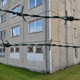 Stacheldraht ist vor einem Plattenbau zu sehen, das zu DDR-Zeiten als NVA-Militärgefängnis genutzt wurde.