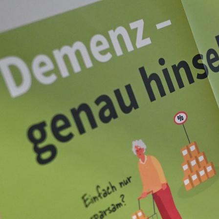 An einer Tür in einem Betreuungs- und Beratungszentrum für Demenzkranke, hängt ein Plakat mit der Aufschrift &#034;Demenz - genau hinsehen!&#034;